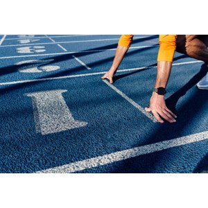 Umělecká fotografie Sportsman at starting line of running track, Westend61, (40 x 26.7 cm)