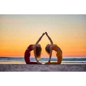 Umělecká fotografie Two women doing yoga on the beach at sunrise, Jose Martinez, (40 x 26.7 cm)