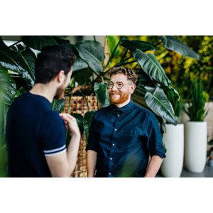 Umělecká fotografie Two Colleagues Standing Amongst Potted Plants, Tom Werner, (40 x 26.7 cm)