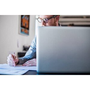 Umělecká fotografie Businessman writing notes at laptop desk, Portra Images, (40 x 26.7 cm)
