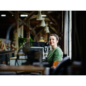 Umělecká fotografie Smiling businesswoman sitting at workstation, Thomas Barwick, (40 x 30 cm)