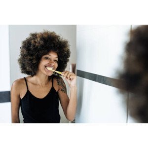 Umělecká fotografie Multiracial woman brushing teeth in bathroom, Drazen_, (40 x 26.7 cm)