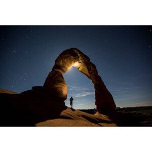 Umělecká fotografie A hiker standing underneath an arch., Jordan Siemens, (40 x 26.7 cm)