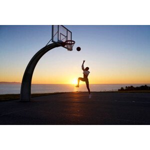 Umělecká fotografie Mid adult woman playing basketball at sunset, Heshphoto, (40 x 26.7 cm)