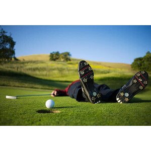 Umělecká fotografie Golfer lying on green, ball on edge of hole, Joe McBride, (40 x 26.7 cm)
