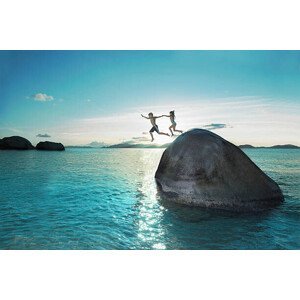 Umělecká fotografie Two kids holding hands jumping off rock into sea, Gary John Norman, (40 x 26.7 cm)